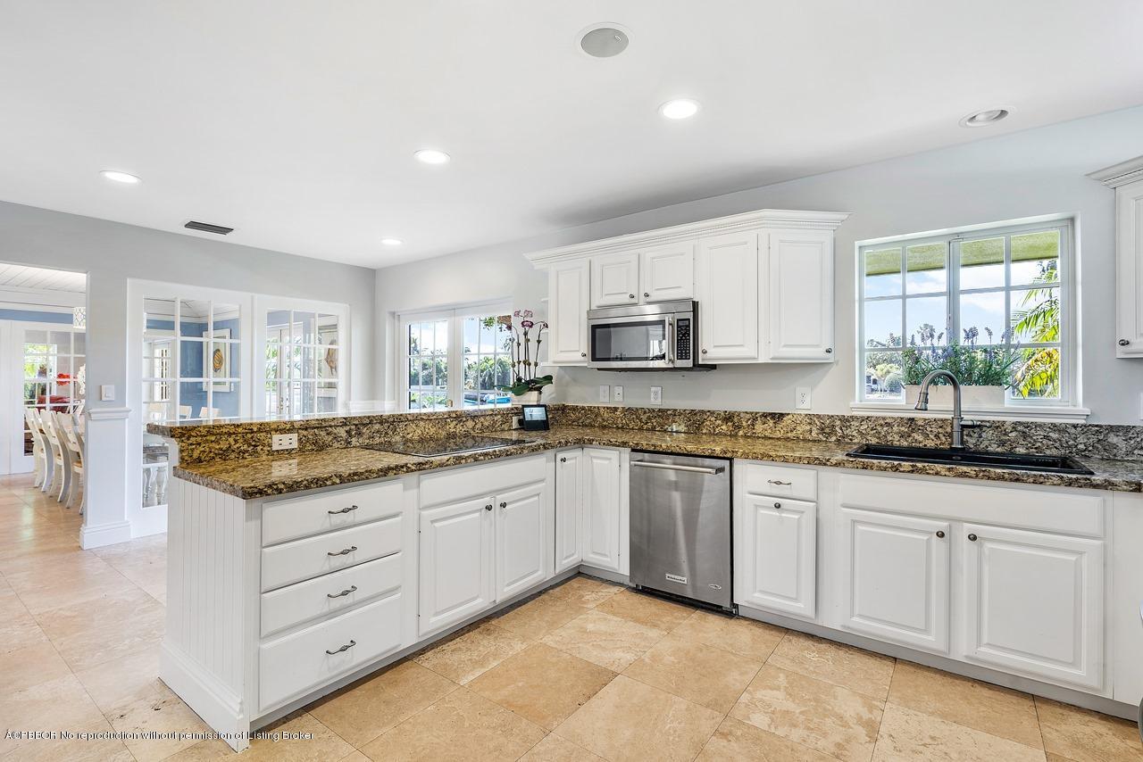 57 River Drive Ocean Ridge, FL 33435 - Photo 8 of 43 a kitchen with granite countertop a sink a stove cabinets and a window