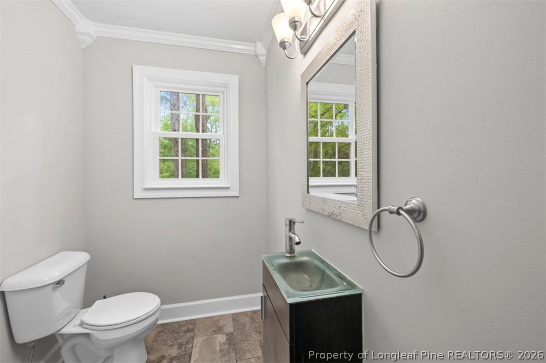 1007 Riverside Boulevard Lumberton, NC 28358 - Photo 14 of 42 a bathroom with a granite countertop toilet a sink and a window