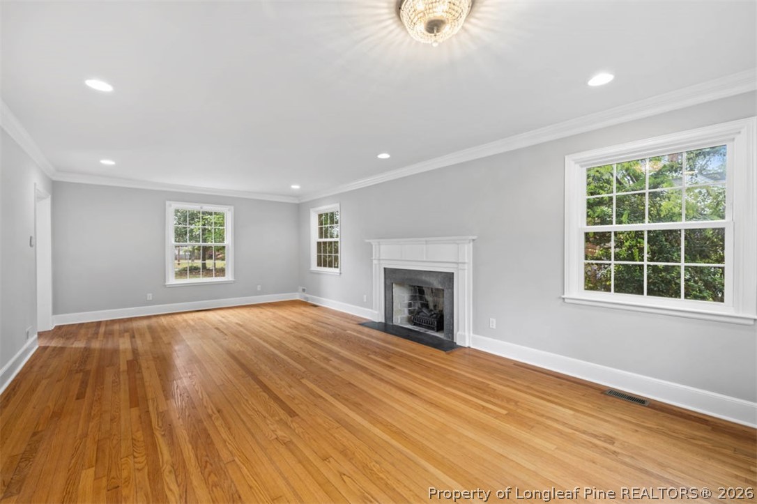 1007 Riverside Boulevard Lumberton, NC 28358 - Photo 20 of 42 an empty room with wooden floor a fireplace and windows