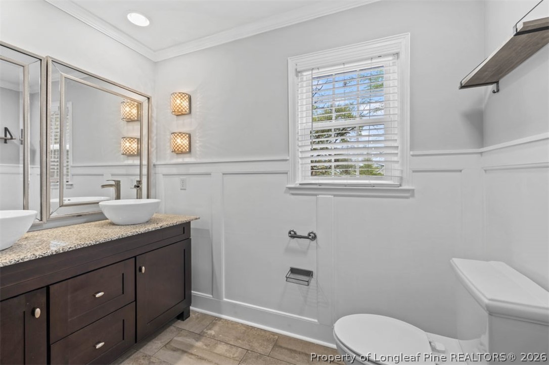1007 Riverside Boulevard Lumberton, NC 28358 - Photo 27 of 42 a bathroom with a granite countertop toilet a sink a mirror a window and vanity