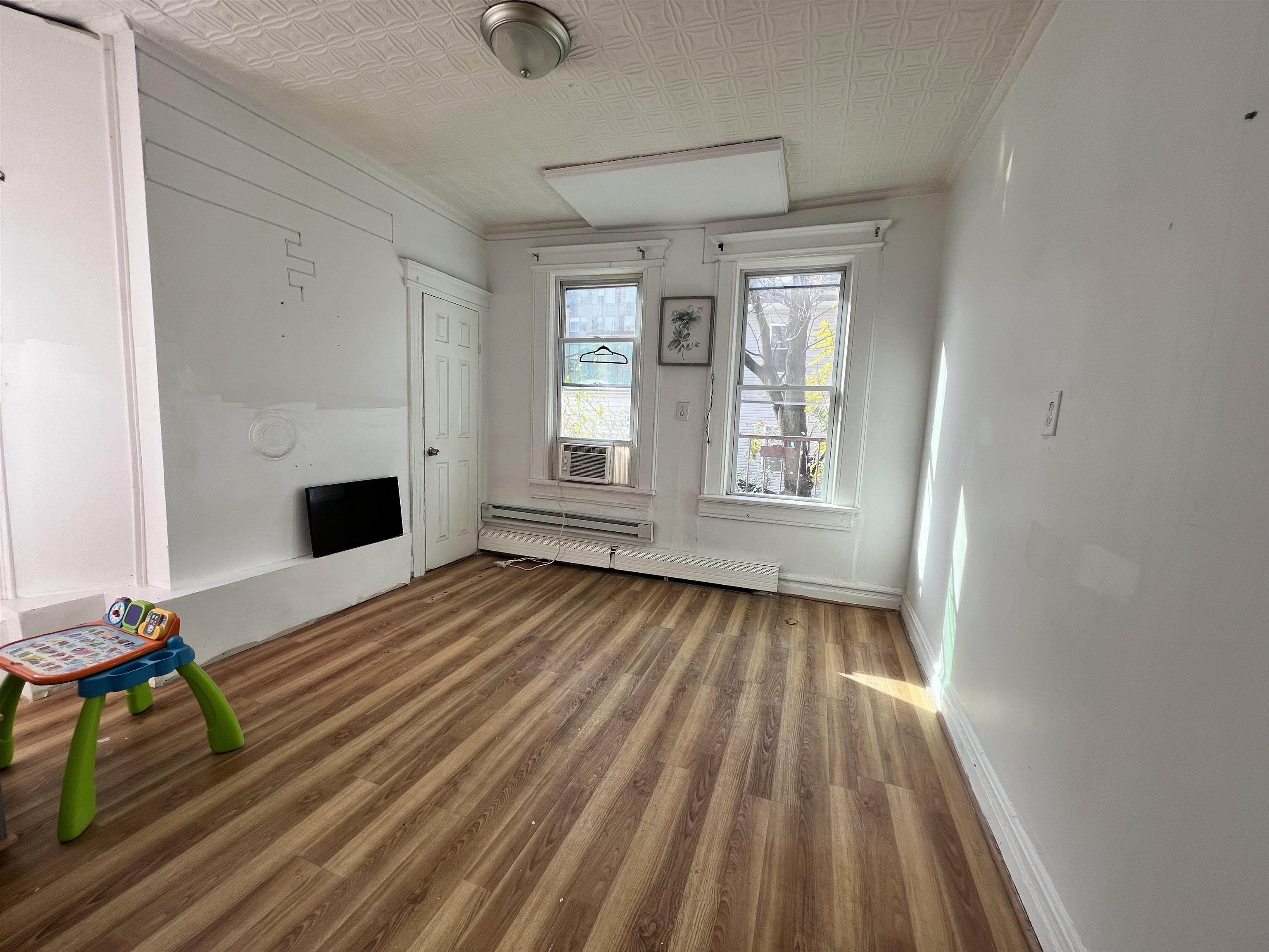 69 Clarke Avenue, Unit 2L Jersey City, NJ 07304 - Photo 2 of 8 a view of empty room with wooden floor and fan