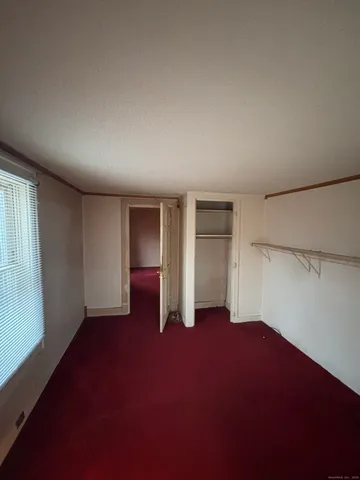 an empty room with closet and windows