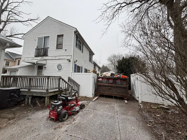 a view of a house with a cars park side of a road