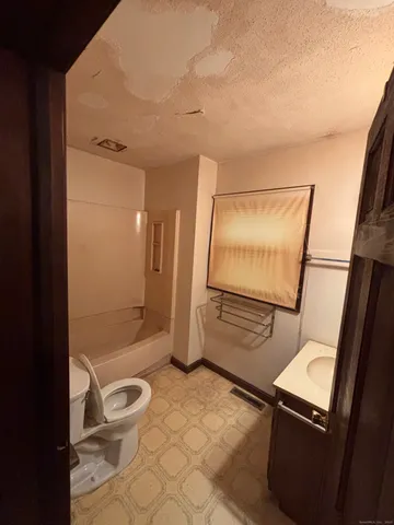 a bathroom with a toilet a sink and shower