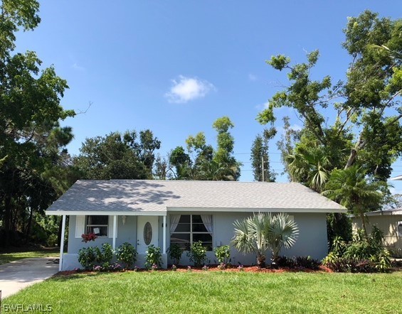 8038 Matanzas Road Fort Myers, FL 33967 - Photo 1 of 27 a front view of a house with garden