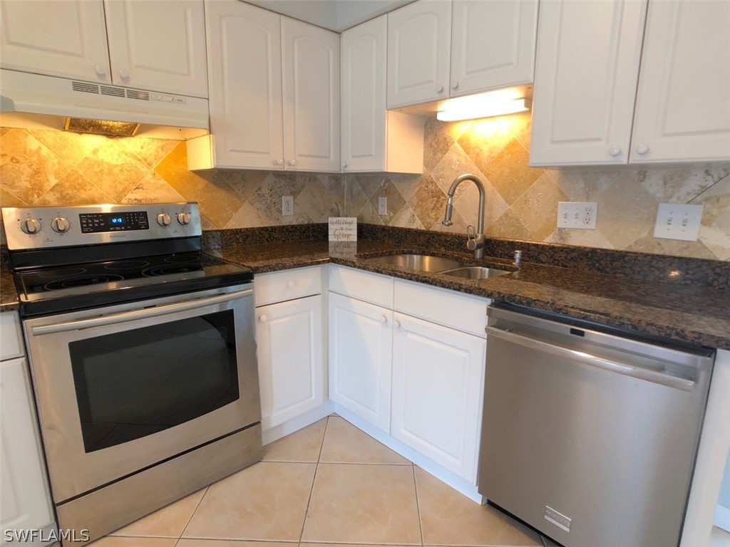 8038 Matanzas Road Fort Myers, FL 33967 - Photo 3 of 27 a kitchen with granite countertop white cabinets stainless steel appliances and a sink