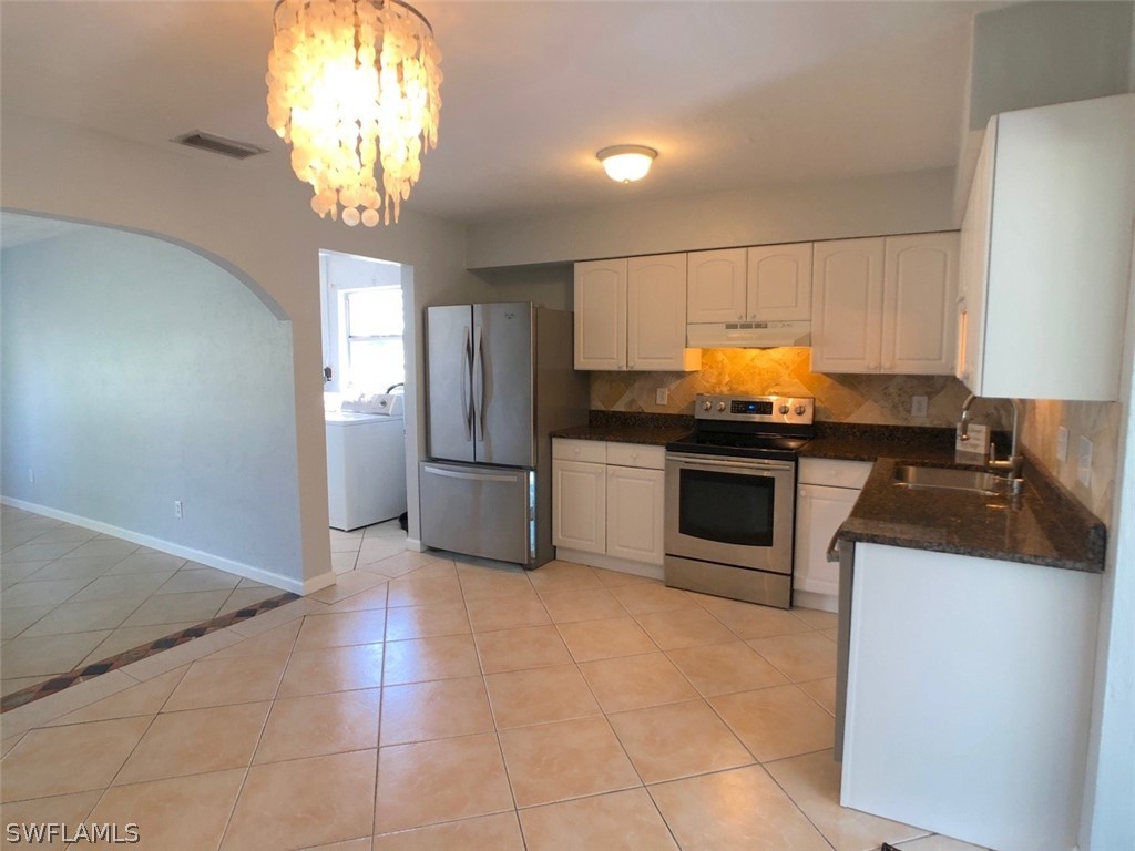8038 Matanzas Road Fort Myers, FL 33967 - Photo 4 of 27 a kitchen with a sink a counter top space cabinets and stainless steel appliances