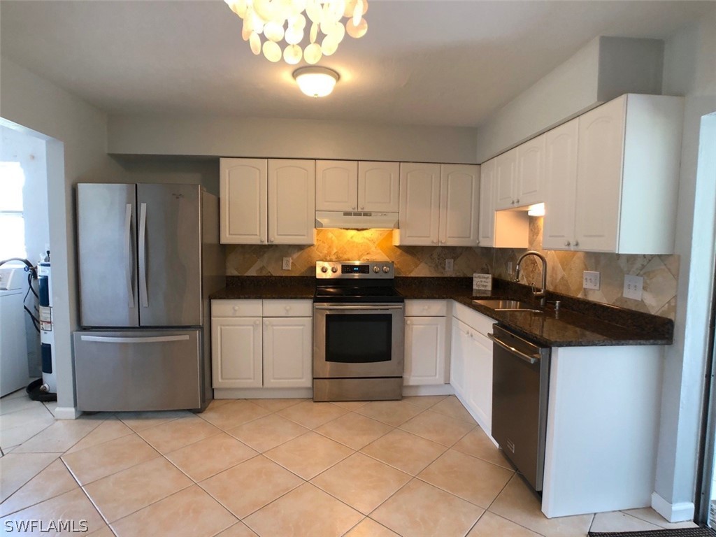 8038 Matanzas Road Fort Myers, FL 33967 - Photo 5 of 27 a kitchen with granite countertop white cabinets and stainless steel appliances