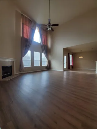 a view of a livingroom with wooden floor fireplace and window
