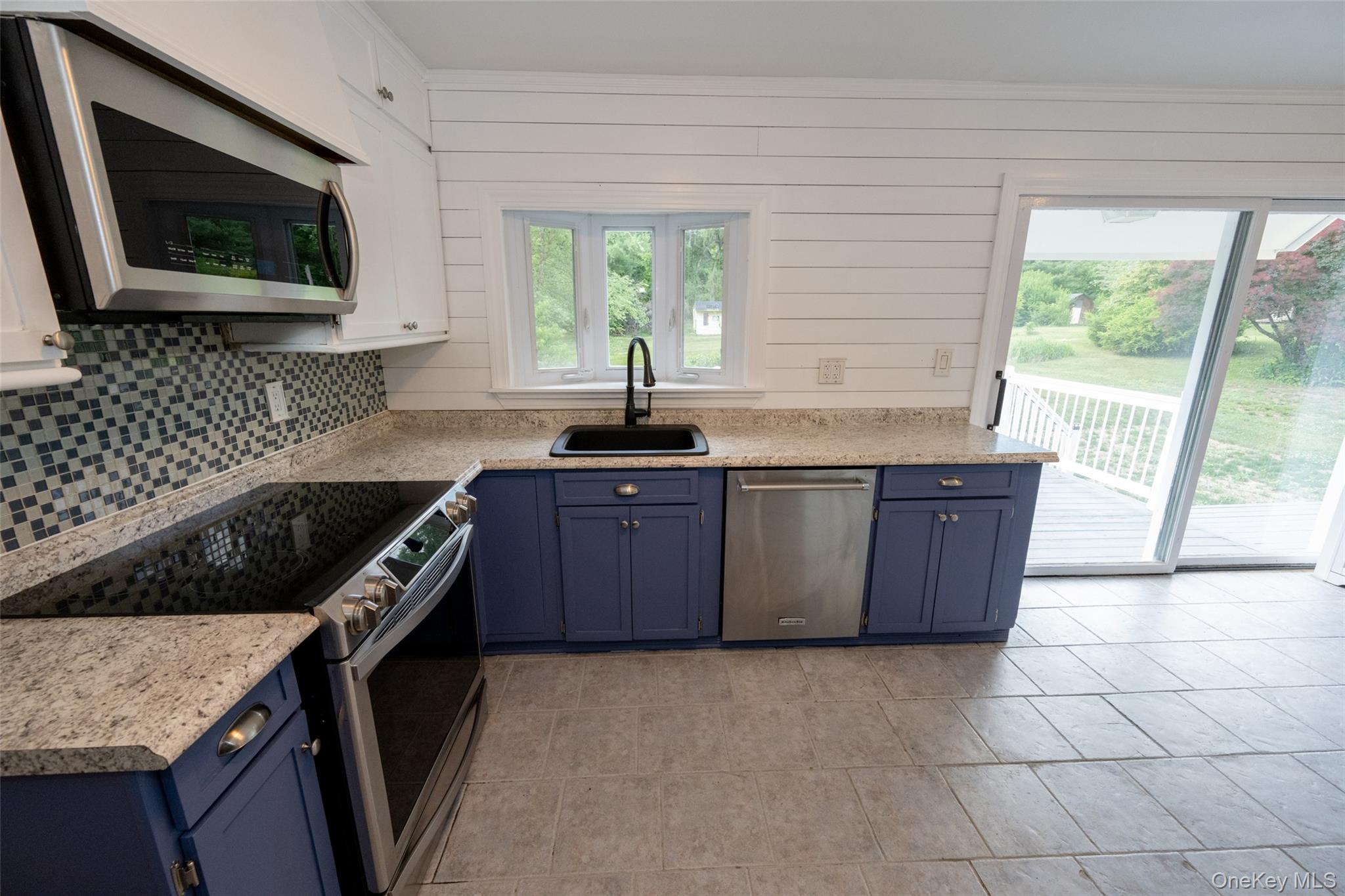 136 Foggintown Road Brewster, NY 10509 - Photo 11 of 50 a kitchen with a stove a sink a microwave a window and cabinets