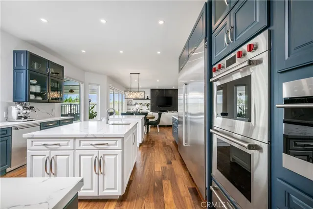 a very nice looking kitchen with granite countertop a stove top oven a sink a counter space and cabinets
