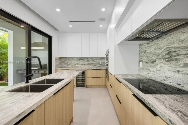 a kitchen with stainless steel appliances granite countertop a sink and a stove