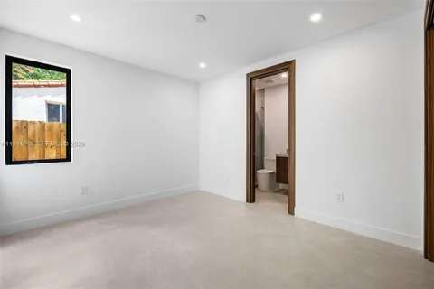 an empty room with a window and a bathroom
