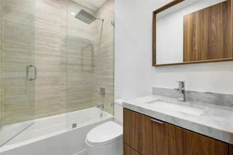 a view of an empty room with wooden floor and windows