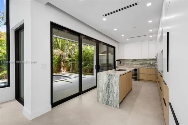 a kitchen with kitchen island a counter top space a sink stainless steel appliances and cabinets