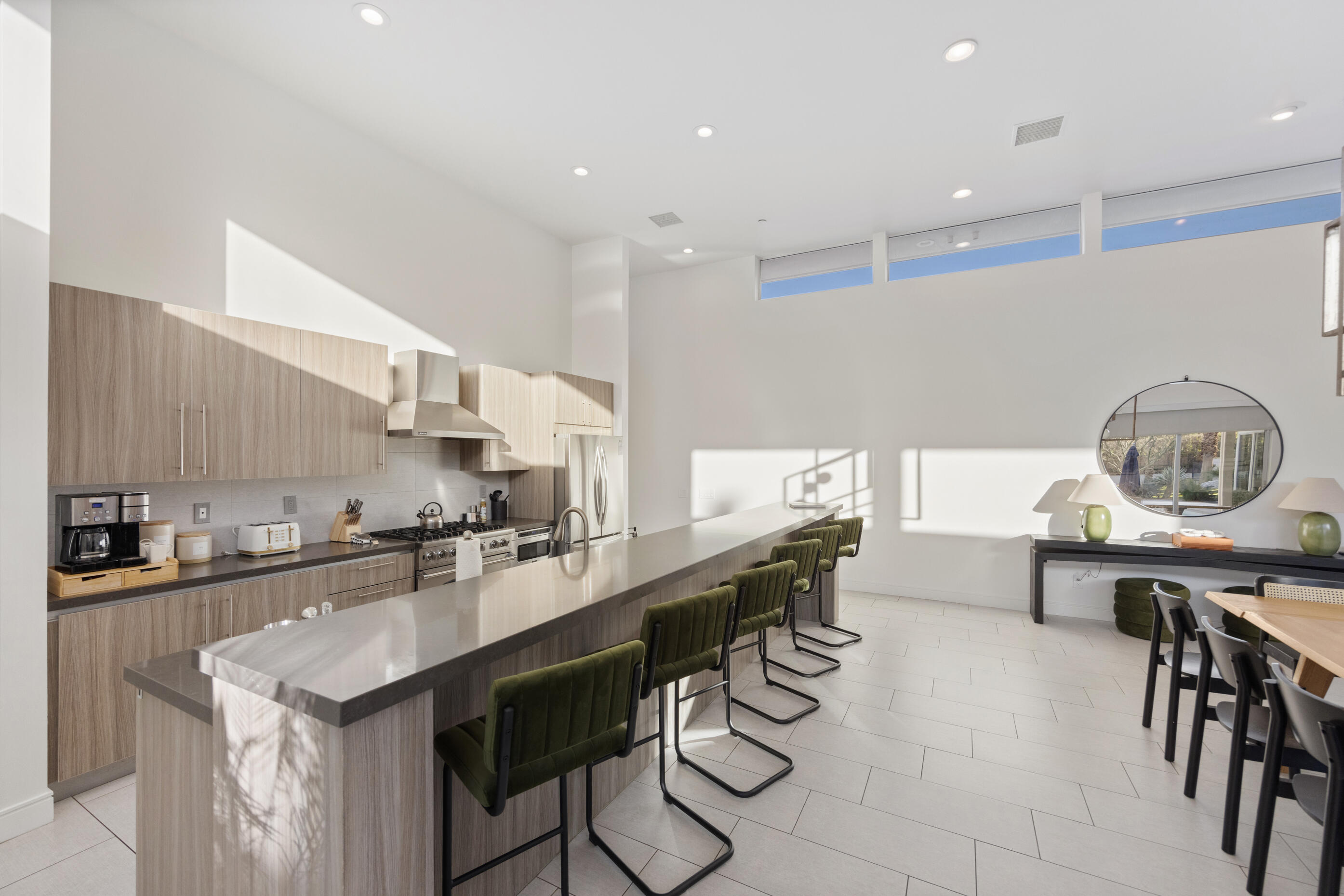 51165 Evangeline Way La Quinta, CA 92253 - Photo 12 of 48 a kitchen with stainless steel appliances kitchen island granite countertop a table chairs sink and cabinets