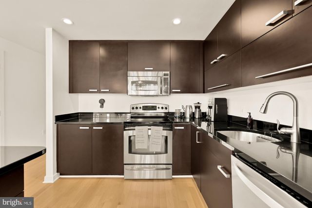 a kitchen with stainless steel appliances granite countertop a sink stove and cabinets