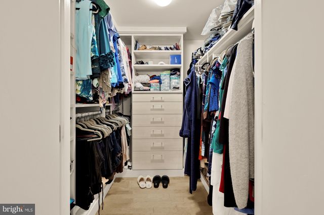 a view of walk in closet with clothes and shoes