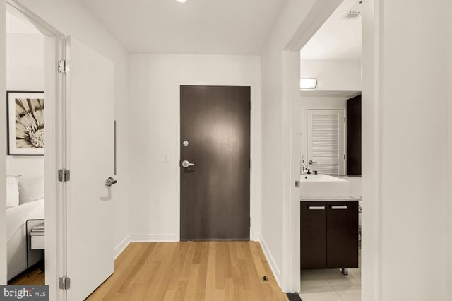 a view of a hallway with wooden floor and closet area