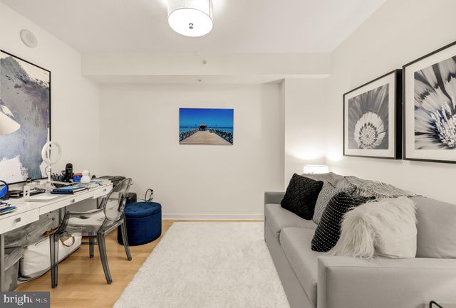 a living room with furniture and a painting on the wall