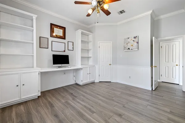 a view of an empty room with a window and a kitchen