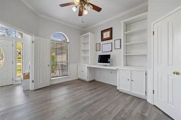 a view of an empty room with a window and wooden floor