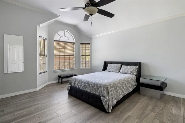 a bedroom with a bed chandelier and a window