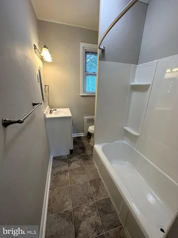 a bathroom with a tub sink and mirror