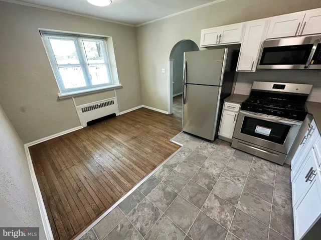 a kitchen with a refrigerator and a stove top oven