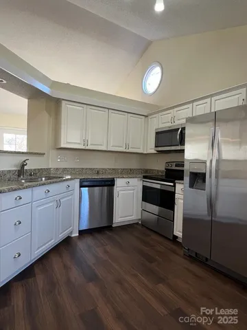 a kitchen with granite countertop stainless steel appliances and wooden cabinets