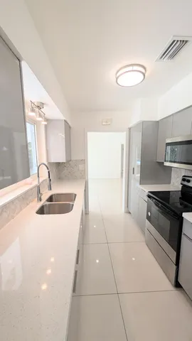 a kitchen with stainless steel appliances a sink stove and cabinets