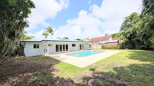 a front view of a house with a garden and trees