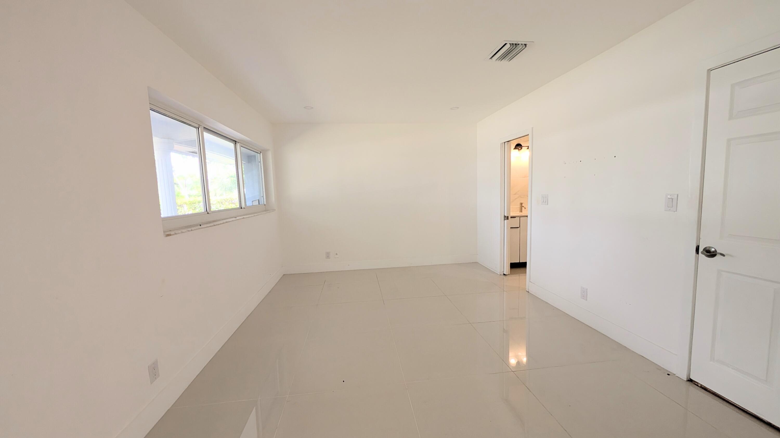 3840 Northeast 22nd Terrace Lighthouse Point, FL 33064 - Photo 3 of 18 an empty room with windows