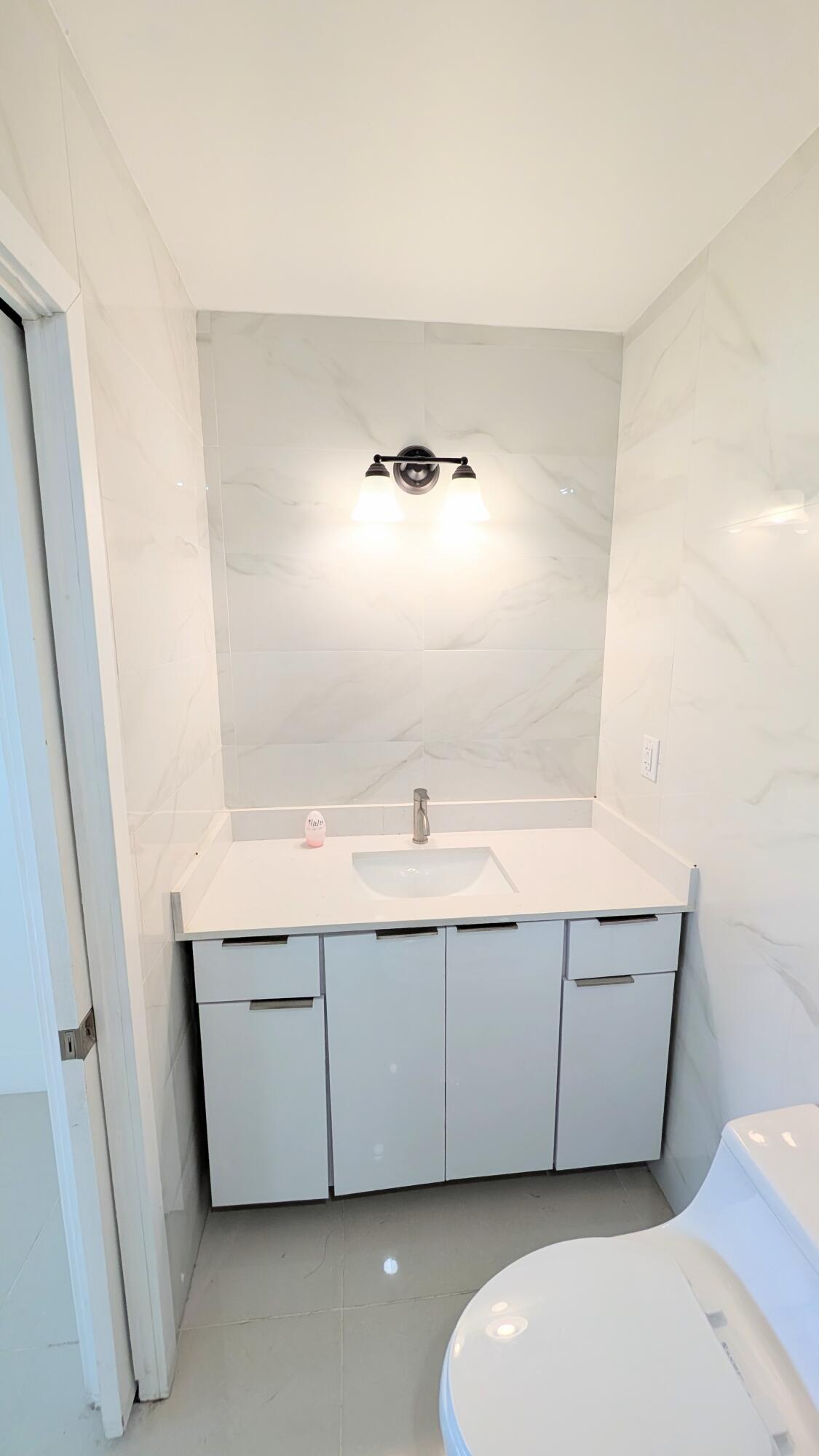 3840 Northeast 22nd Terrace Lighthouse Point, FL 33064 - Photo 5 of 18 a bathroom with a sink and a mirror