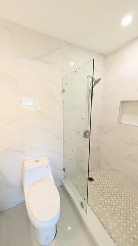 a bathroom with a toilet and a shower