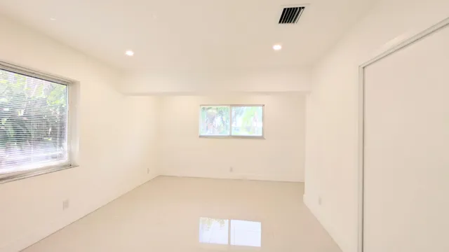 a view of a big room with wooden floor and windows