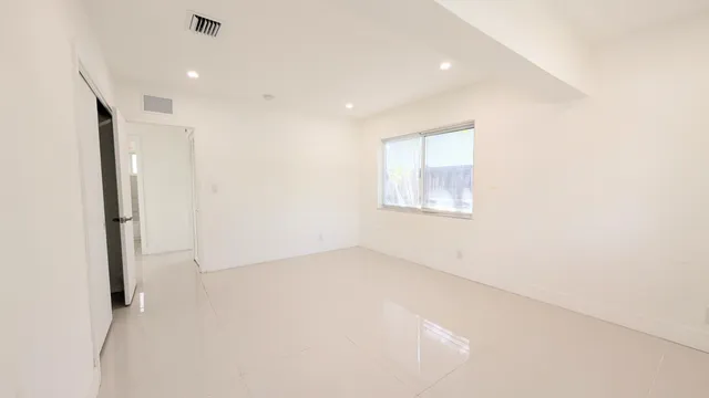 an empty room with windows and closet