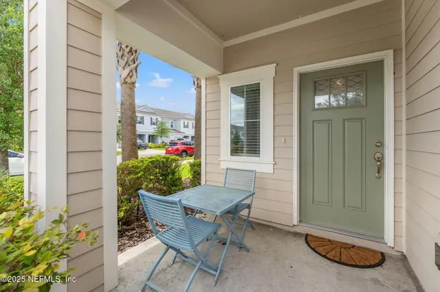 a view of a porch with a table and chairs and potted plants