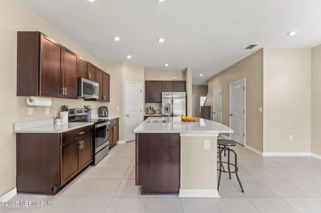 a large kitchen with stainless steel appliances and a stove top oven
