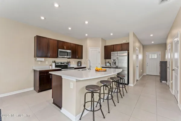 a kitchen with stainless steel appliances a refrigerator a stove a microwave and a refrigerator