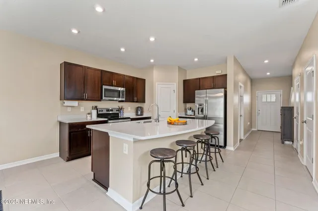 a kitchen with stainless steel appliances a refrigerator a stove a microwave and a refrigerator