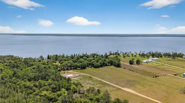 an aerial view of a house with a yard and lake view