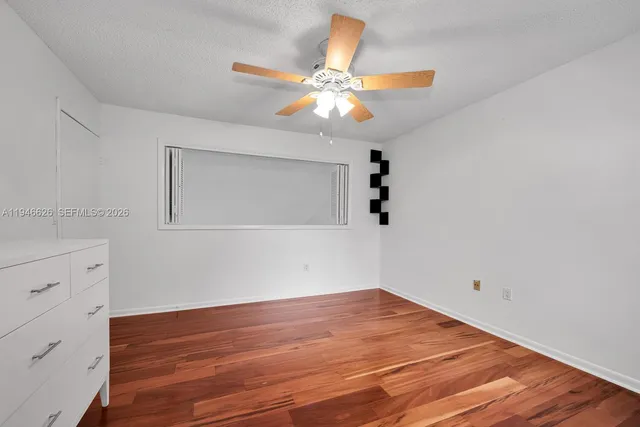 a view of a room with wooden floor and fan