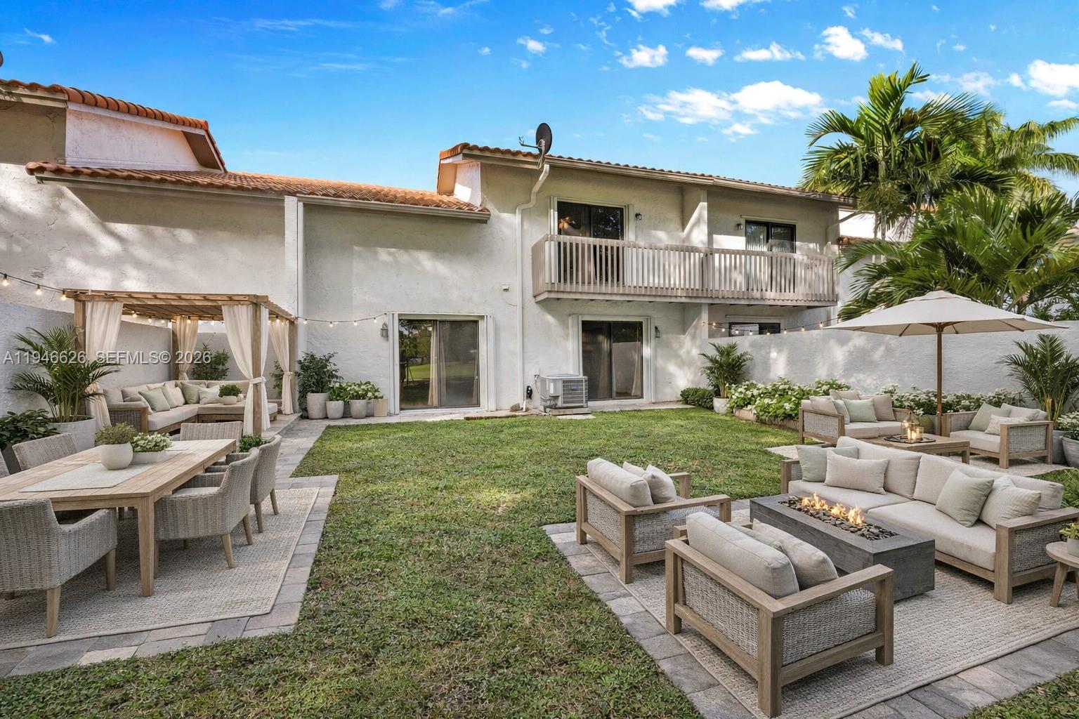 13121 Southwest 95th Avenue Miami, FL 33176 - Photo 22 of 41 a view of a patio with couches table and chairs with potted plants and a big yard