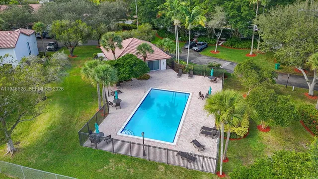 an aerial view of a house with a yard and swimming pool