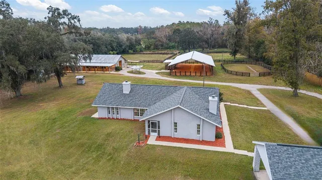 an aerial view of a house with swimming pool and mountains