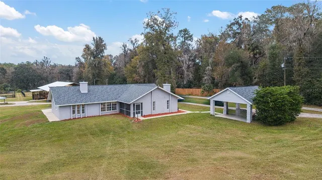 a aerial view of a house with yard and a swimming pool