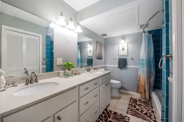 a bathroom with a double vanity sink mirror and toilet