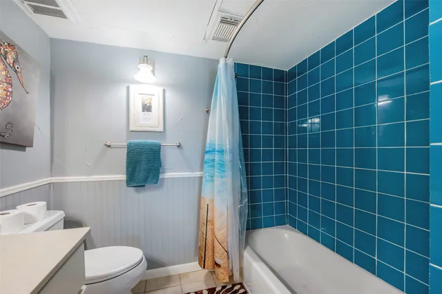 a bathroom with a sink a toilet a mirror and shower