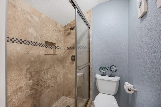 a bathroom with a toilet and a shower